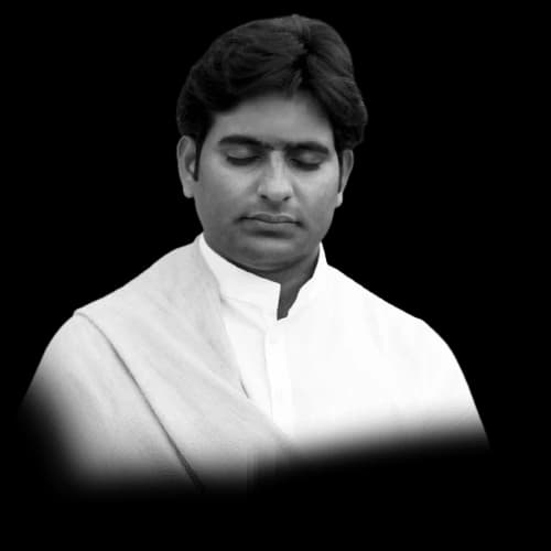 Dr. D.P. Shukla in a white shawl, eyes closed in meditation