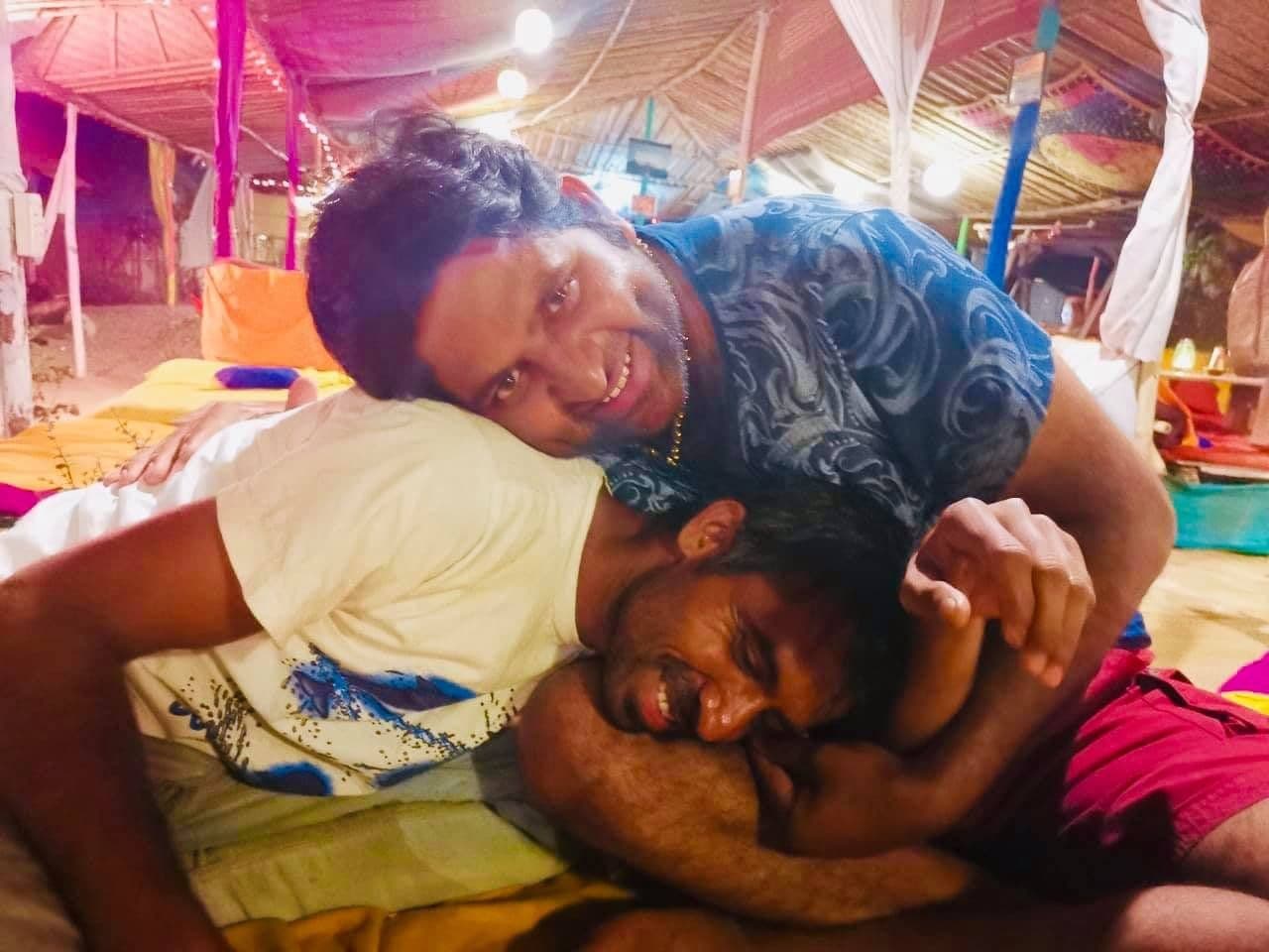 Dr. D.P. Shukla laughing with a friend under a festival tent