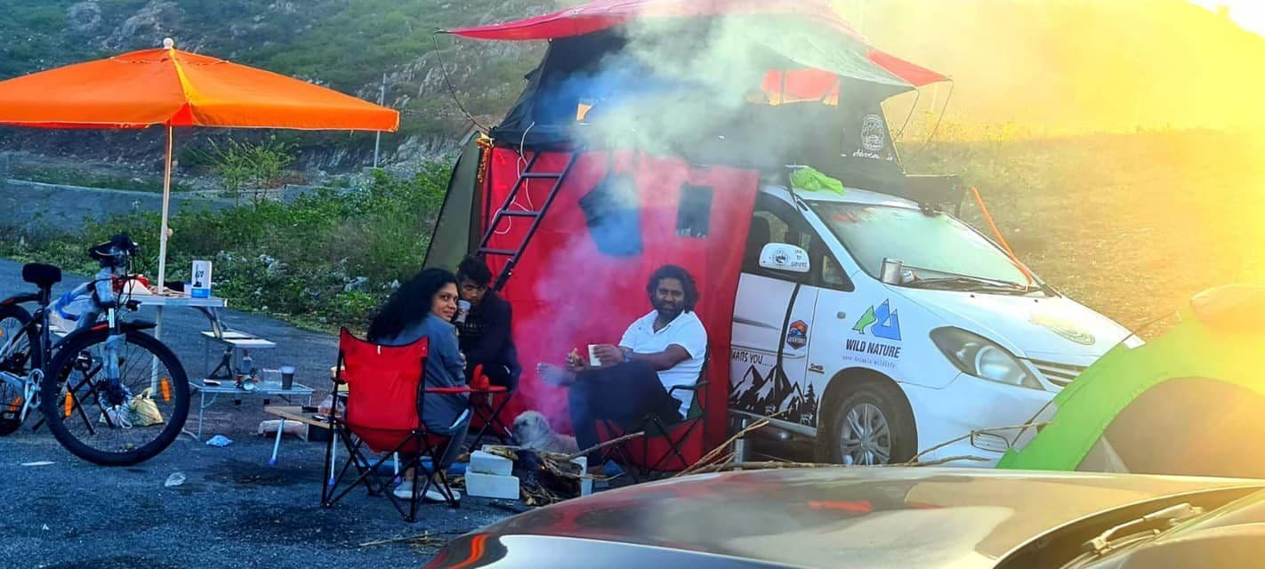 A campervan and camp chairs at a mountain stop