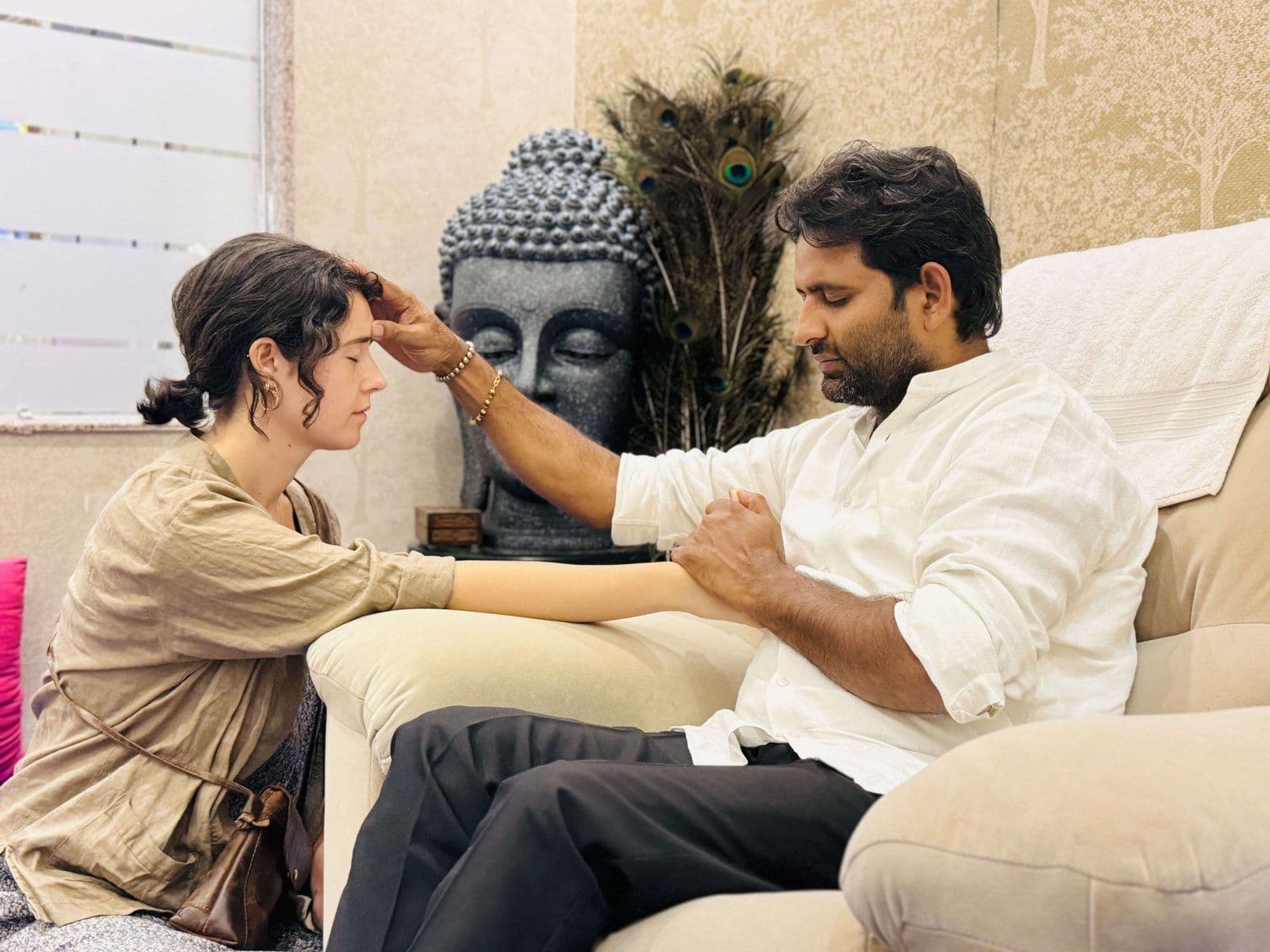 Dr. D.P. Shukla placing a hand on a woman’s forehead during a session