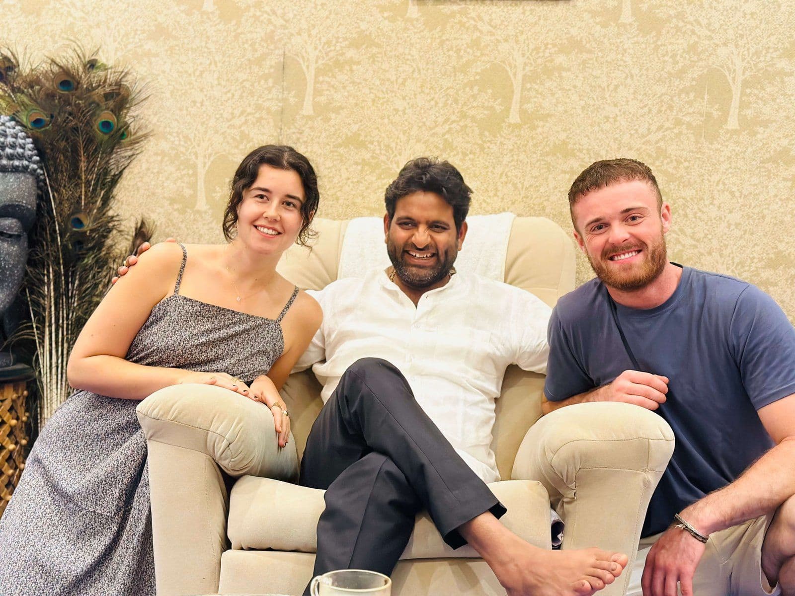 Dr. D.P. Shukla seated on a sofa between two young visitors in the consultation room