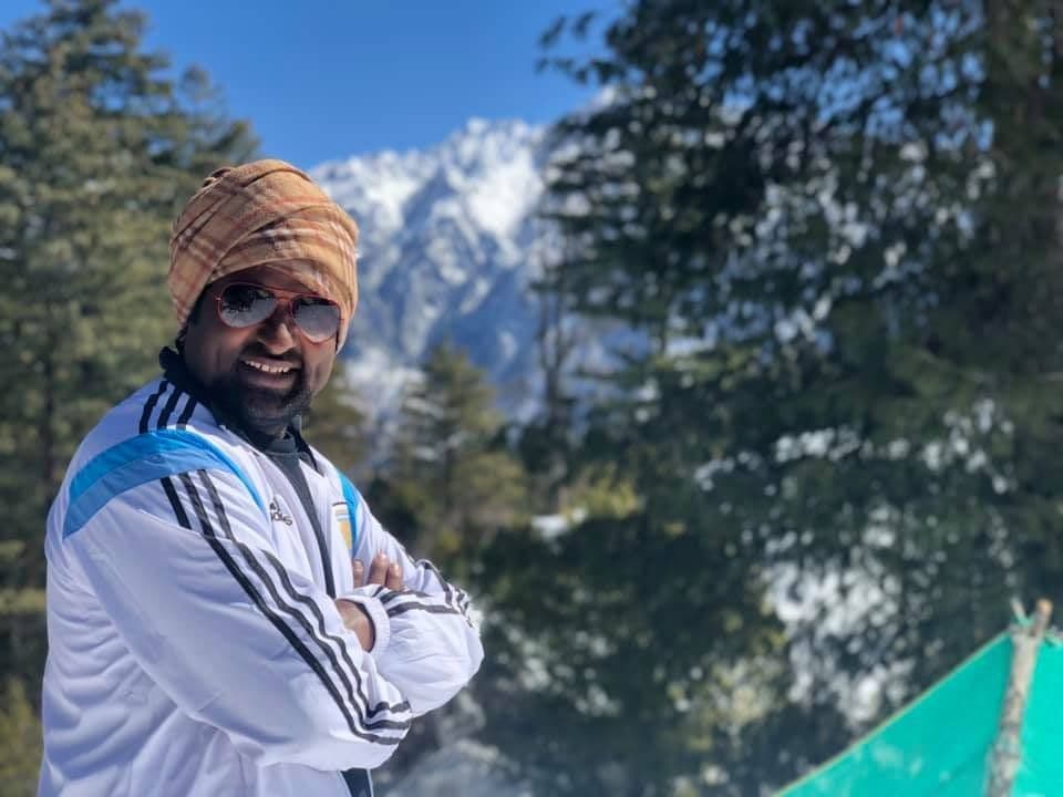 Dr. D.P. Shukla in a knitted cap and sunglasses in the mountains
