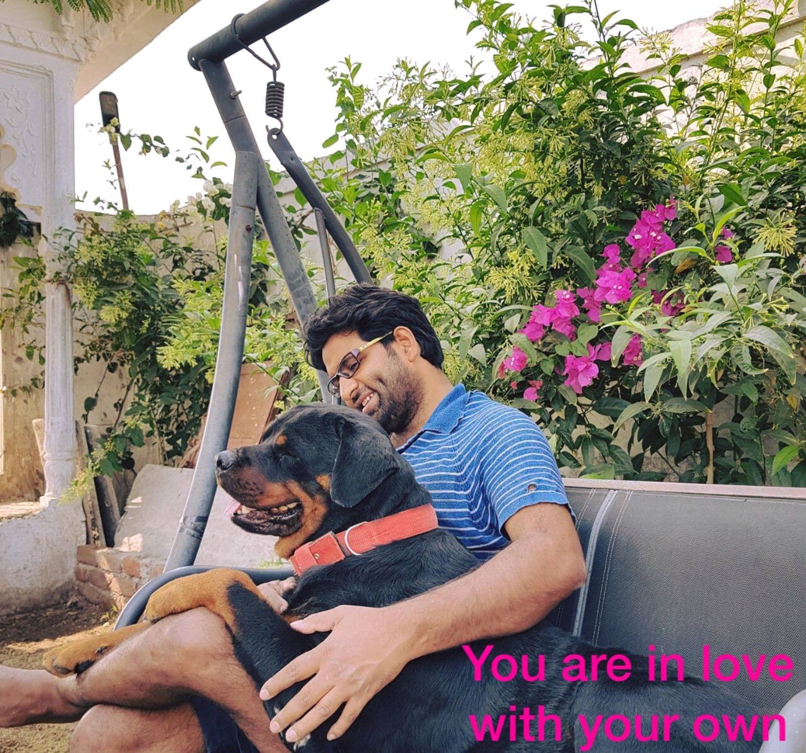 Dr. D.P. Shukla relaxing on a garden swing with his rottweiler