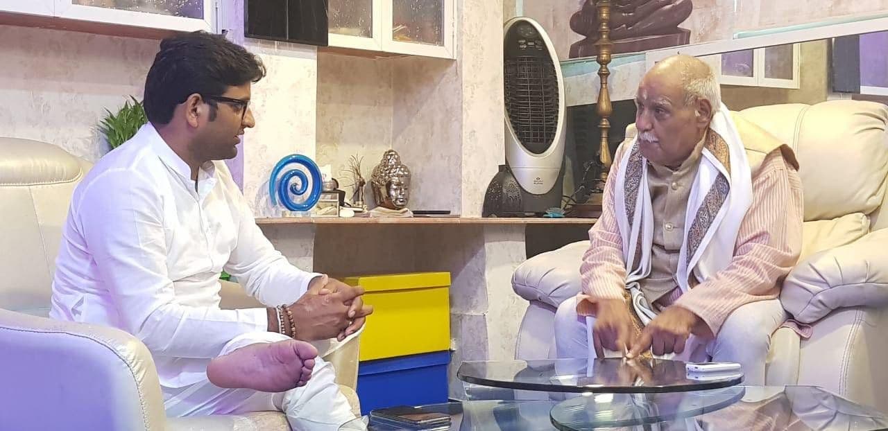 Dr. D.P. Shukla in conversation with an elderly man dressed in white