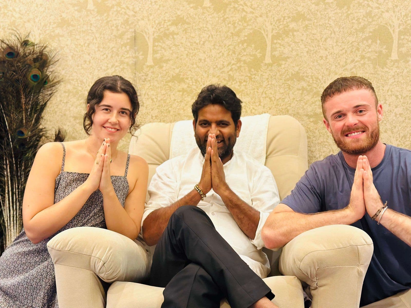 Dr. D.P. Shukla seated between a young woman and a young man, all with folded hands