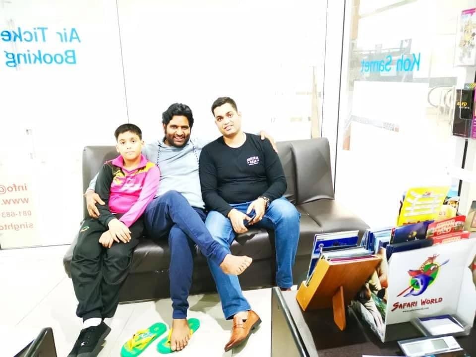 Dr. D.P. Shukla with a child and a man on an office sofa