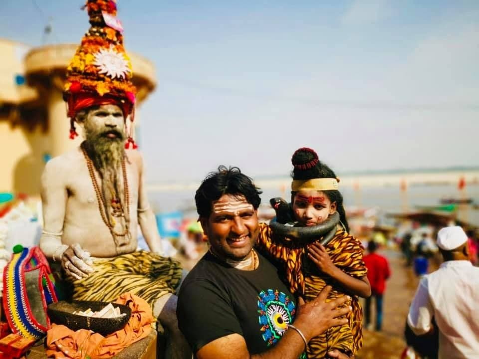 Dr. D.P. Shukla with a sadhu and a child dressed as Shiva at a riverside ghat