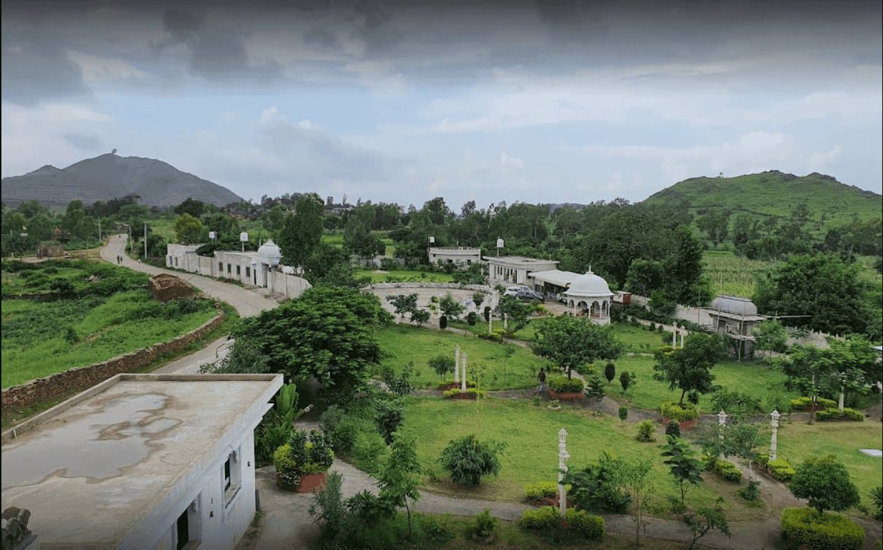Aerial view of Anantpuram: green grounds and low buildings among hills