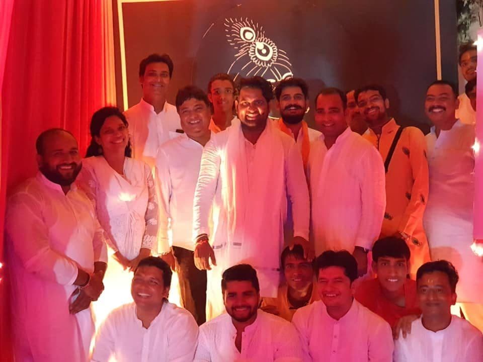 A large group dressed in white at an evening celebration