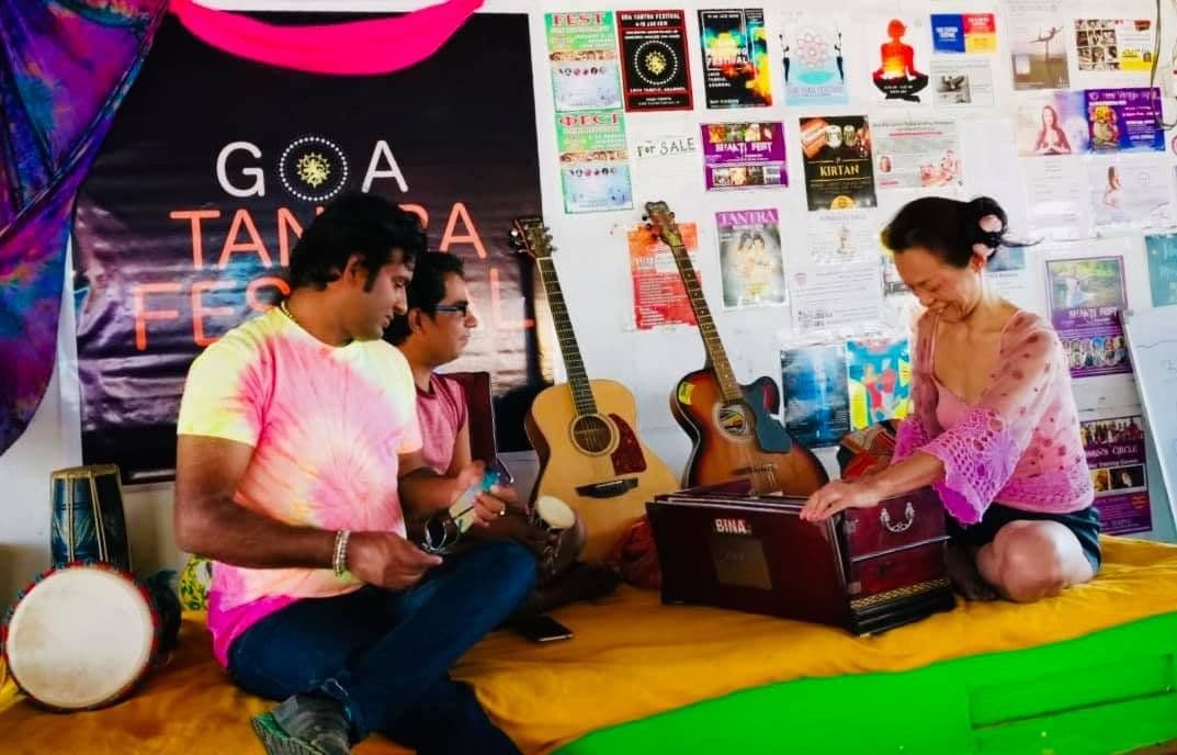 Dr. D.P. Shukla with musicians and a harmonium in a festival tent