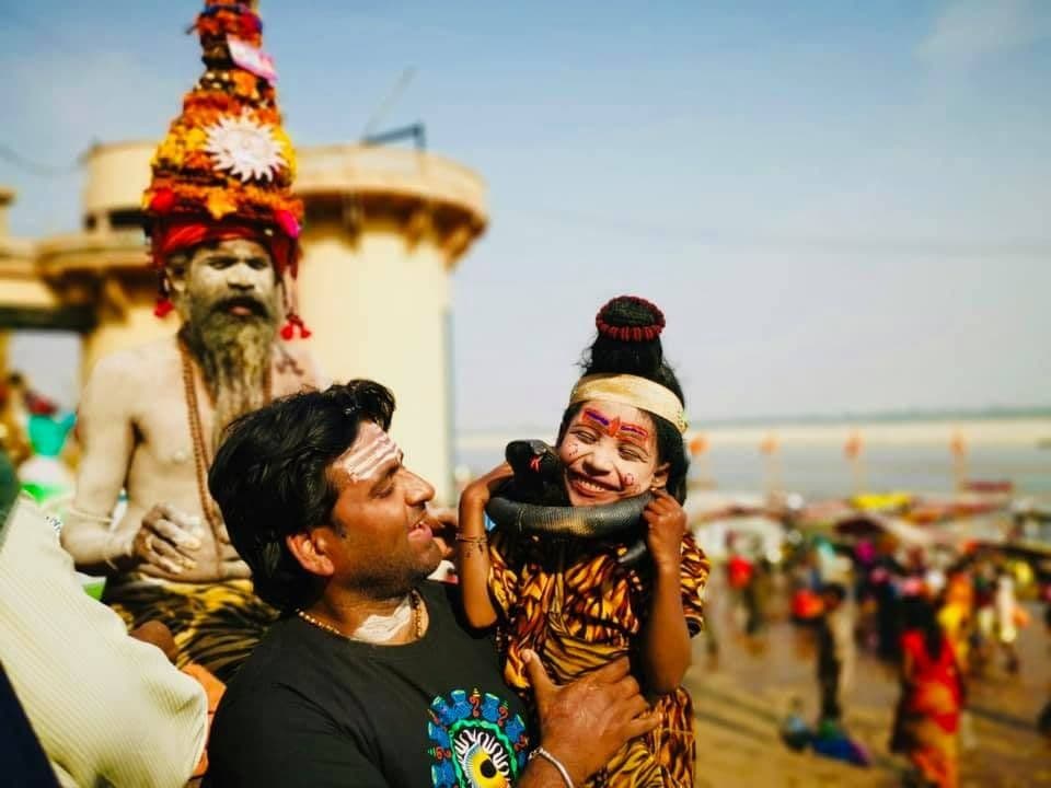 Dr. D.P. Shukla with a sadhu and a child dressed as Shiva at a riverside ghat
