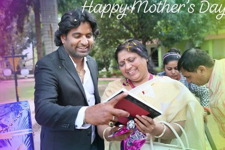 Dr. D.P. Shukla reading from a book with a smiling woman, with a Mother’s Day greeting
