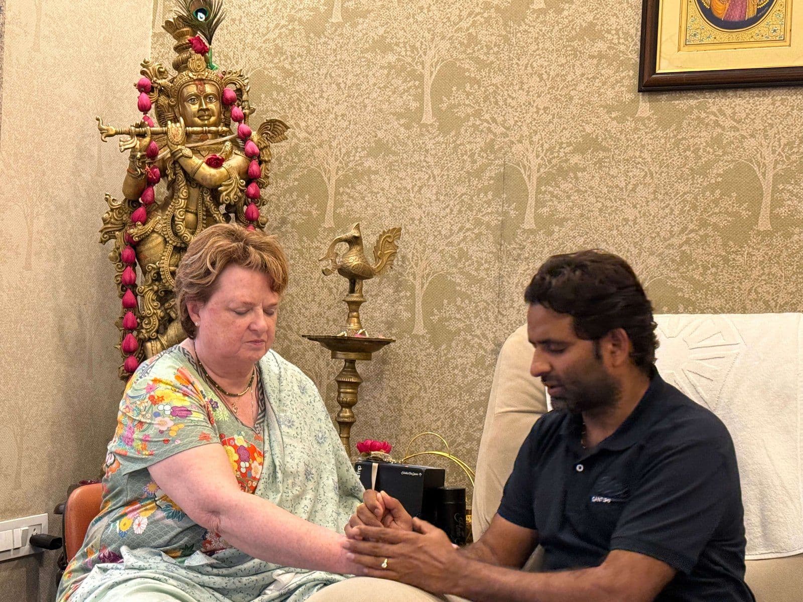 Dr. D.P. Shukla holding a visitor’s hands during a session