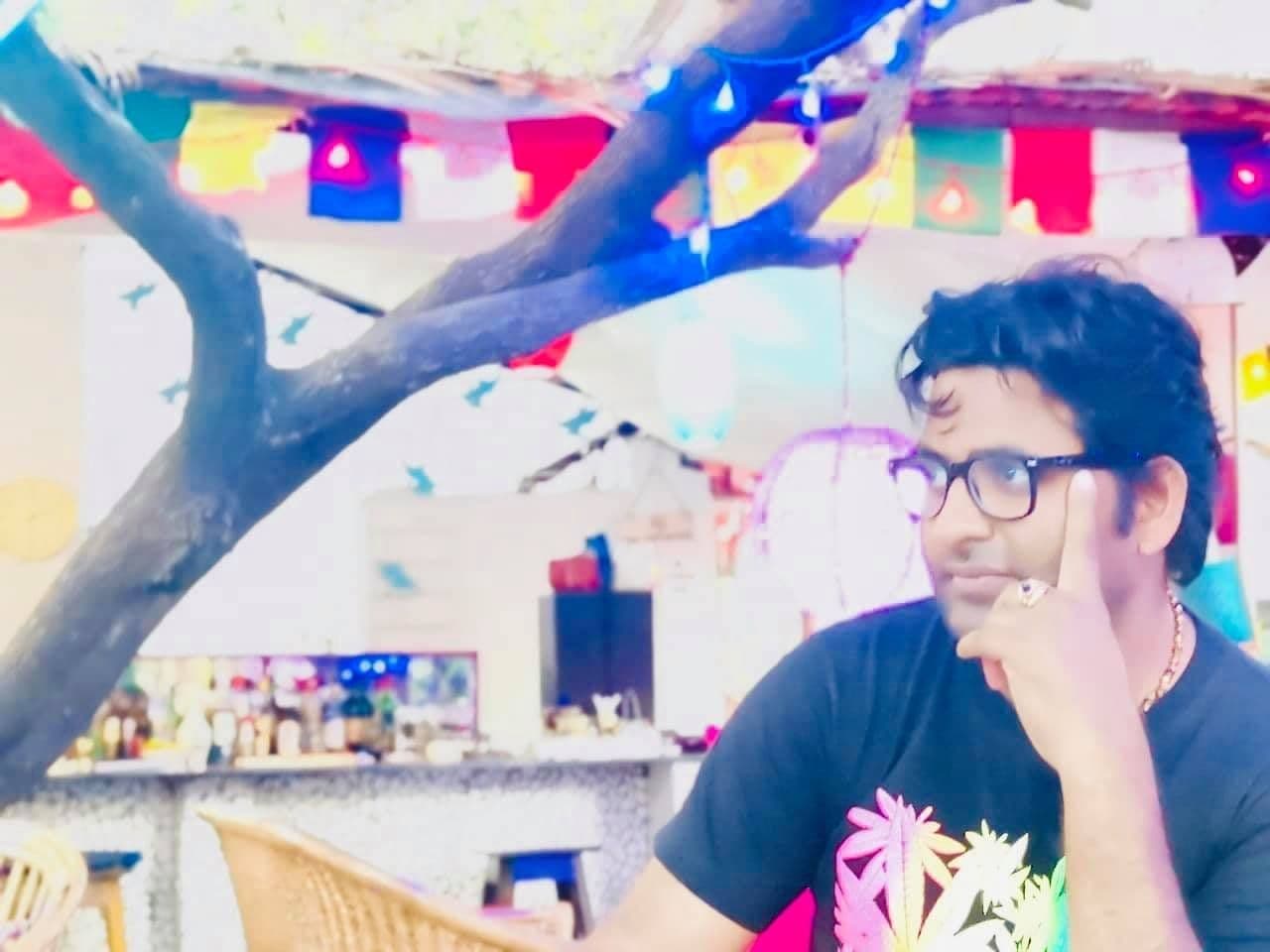 Dr. D.P. Shukla in a thoughtful pose at a colourful café