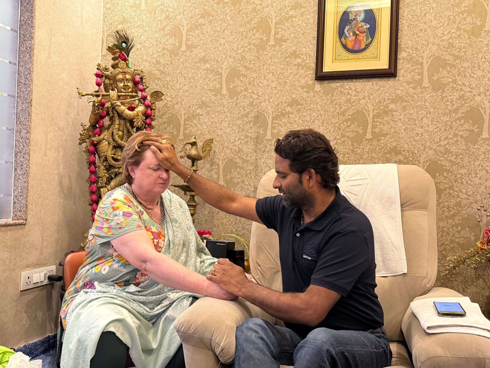 Dr. D.P. Shukla placing a hand on a visitor’s forehead in the consultation room