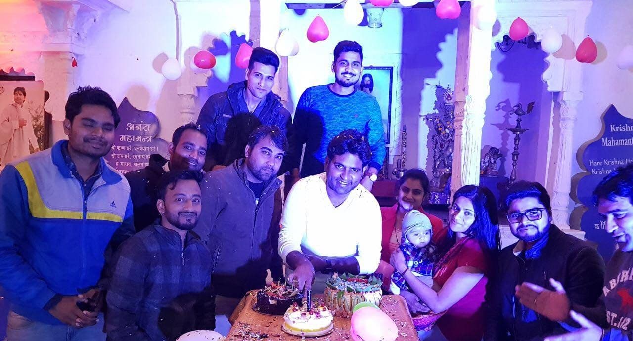 Friends celebrating a birthday with a cake at night