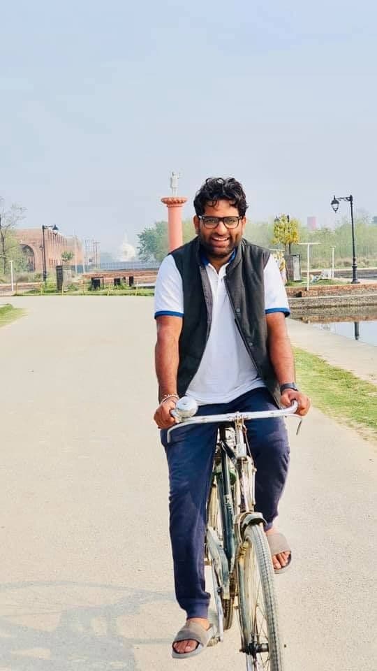 Dr. D.P. Shukla cycling along a lakeside road