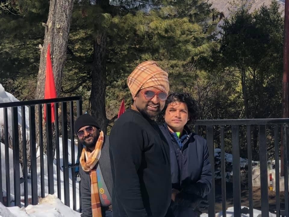 Dr. D.P. Shukla with friends in winter clothes on a balcony at night